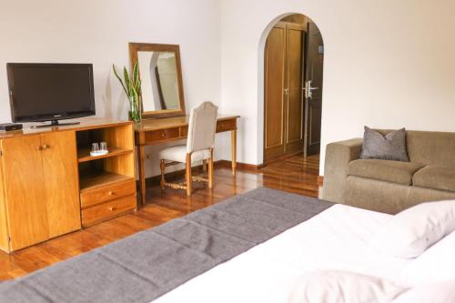 a bedroom with a bed and a desk with a television at Terrazas Vista Verde in Asuncion