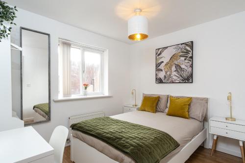 a white bedroom with a bed and a mirror at Wyllie Mews in Burton upon Trent