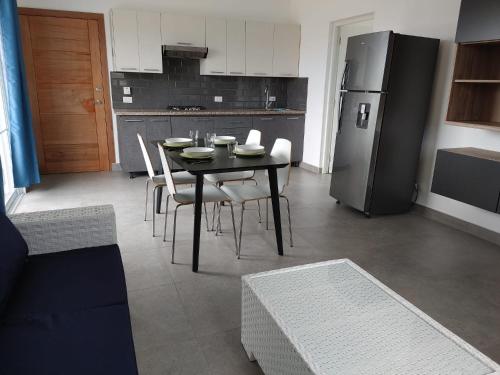 a kitchen with a table and chairs and a refrigerator at Villa Roberta in Boca Chica