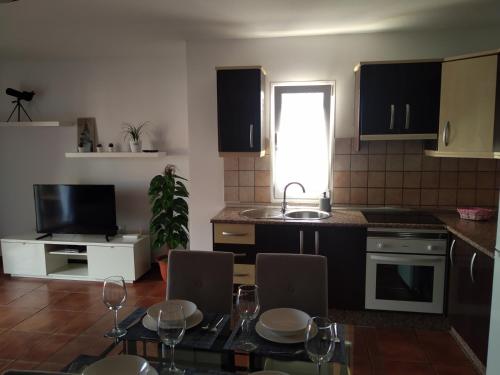 a kitchen with a table with chairs and a sink at ELE HAUSE Tropical Paradise in Tarajalejo