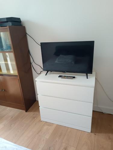 Elle comprend une télévision à écran plat et des robes blanches. dans l'établissement Jolie studio, à Saint-Pourçain-sur-Sioule