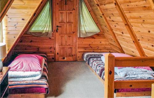 a bedroom with two beds in a log cabin at Beautiful Home In Kartuzy With Kitchen in Kartuzy