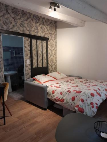 - une chambre avec un lit et une couette rouge et blanche dans l'établissement Petit cocon en plein centre historique d'Uzès - Place aux herbes en zone piétonnière, à Uzès