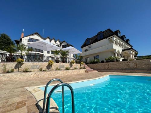 uma casa com piscina em frente a uma casa em Cardinale Resort em Iaşi