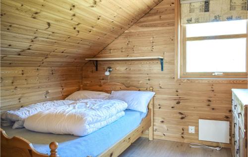 een bed in een houten hut met een raam bij Beautiful Home In Os With Kitchen 
