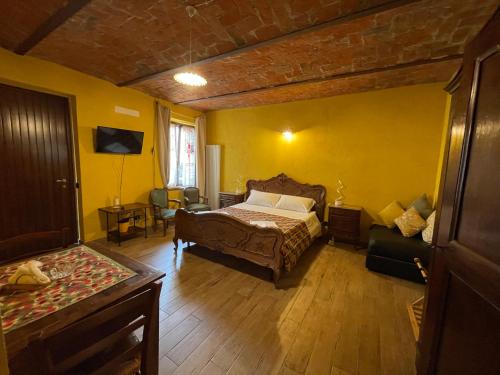 1 dormitorio con cama y pared amarilla en Le camere del Tiglio, en Treiso