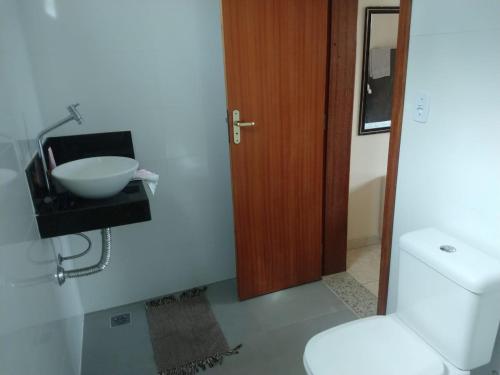 a bathroom with a white toilet and a sink at Sitio Lugar de Descanso em Lagoa Santa in Jaboticatubas