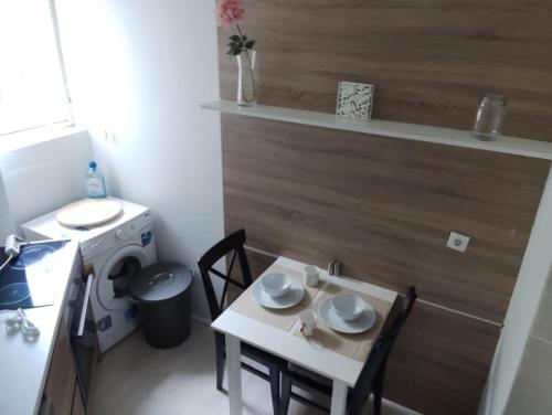 una pequeña cocina con mesa, sillas y fregadero en Nice apartment in New Belgrade with free parking, en Belgrado