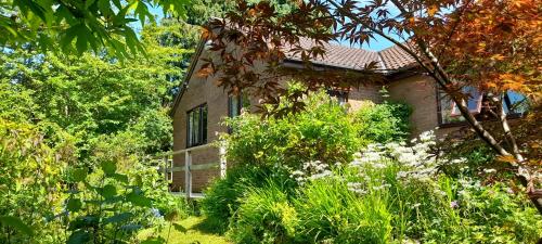 a house in the middle of a garden at Dilkara Apartment Glastonbury in Glastonbury