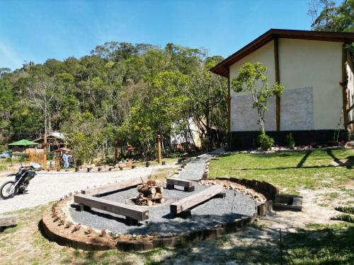 a park with a bench in front of a building at CHALÉS LUAR DO PICO in Santo Antônio do Pinhal