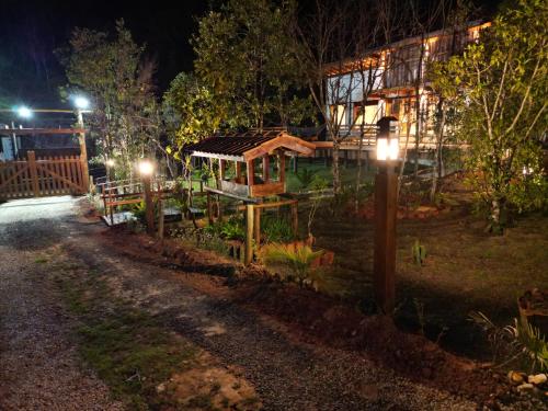 a garden at night with lights on a house at CHALÉS LUAR DO PICO in Santo Antônio do Pinhal