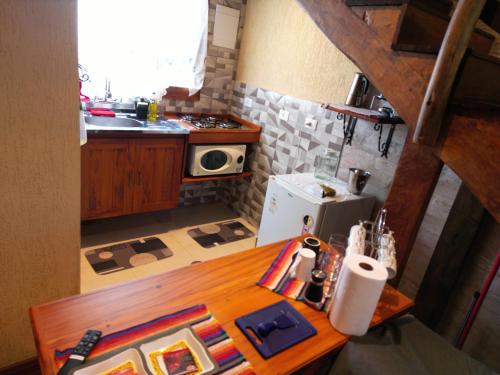 a small kitchen with a wooden table and a stove at CHALÉS LUAR DO PICO in Santo Antônio do Pinhal