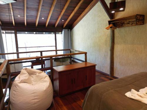 a room with two beds and a desk and a bed sqor at CHALÉS LUAR DO PICO in Santo Antônio do Pinhal