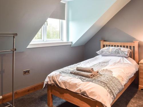 a bedroom with a bed with two towels on it at West Cottage Todrig Farm in Greenlaw