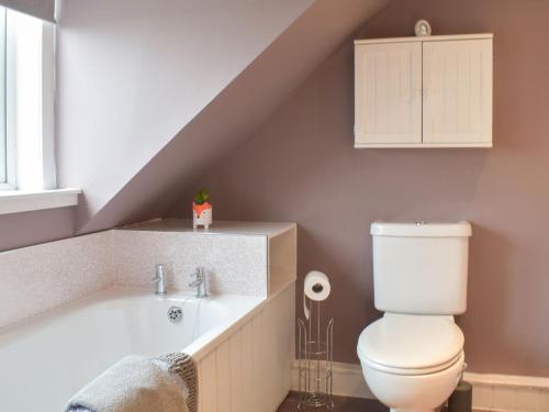 a bathroom with a toilet and a bath tub at West Cottage Todrig Farm in Greenlaw