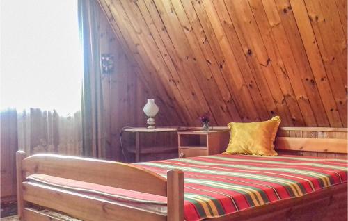 a bedroom with a bed with a wooden wall at Gorgeous Home In Gietrzwald With Kitchen in Kręsk