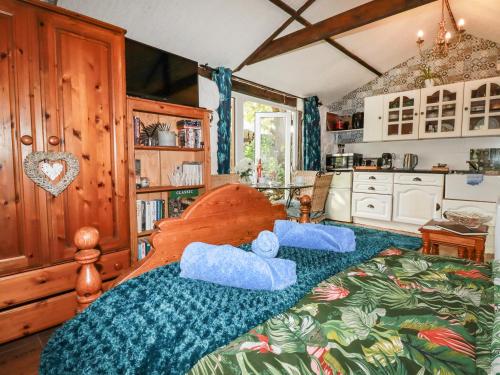 Un dormitorio con una cama con almohadas azules. en Carminow Barn en Bodmin
