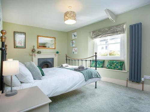 a bedroom with a bed and a fireplace at The Barn House in Ugborough