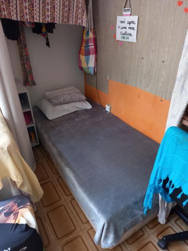 uma cama num pequeno quarto com uma placa na parede em Cama em dormitório misto em Brasília
