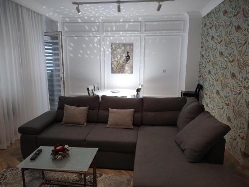 uma sala de estar com um sofá castanho e uma mesa em Decebal Premium Confort em Craiova