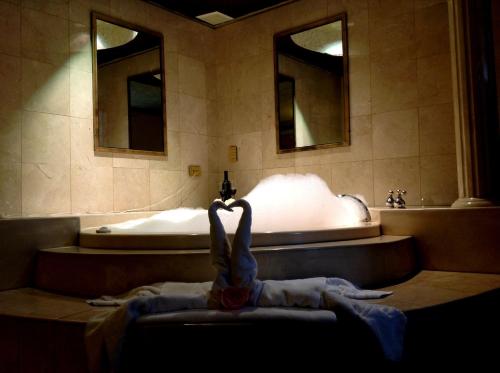 a bathroom with a tub and a sink and a towel at Sunio City in Tijuana