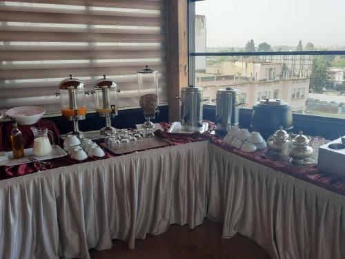 a table with cups and vases on top of it at Hôtel Volubilis Meknès in Meknès