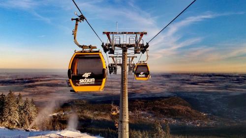 two gondolas on a ski lift in the snow at Apartamenty Larice - balia lub sauna sesja gratis ten weekend, morsowanie w basenie in Świeradów-Zdrój