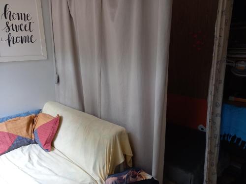 1 dormitorio con cortina blanca y cama con almohada en Cama em dormitório misto, en Brasilia