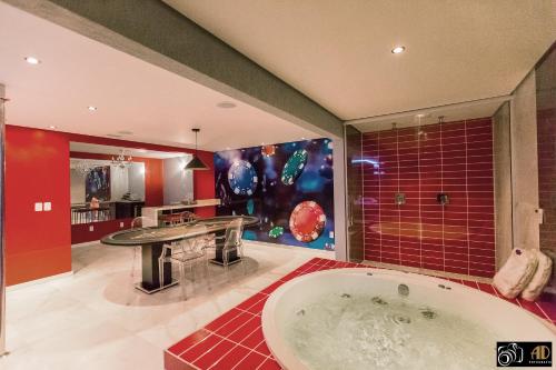 a large bathroom with a tub and a sink at Bangalô Motel by Drops in Santa Maria