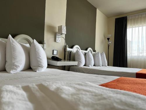 a hotel room with two beds with white pillows at HOTEL LOS ROBLES in Nuevo Laredo