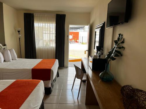 a hotel room with two beds and a television at HOTEL LOS ROBLES in Nuevo Laredo