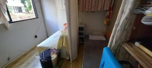 Habitación pequeña con cama y ventana en Cama em dormitório misto, en Brasilia