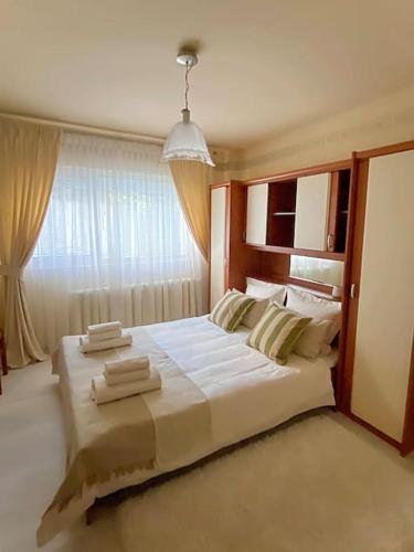 1 cama blanca grande en una habitación con ventana en Lovely & quiet 1-bedroom condo with free parking, en Bucarest