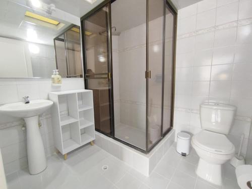 a bathroom with a shower and a toilet and a sink at HABITACION 8 AMPLIA baño y balcón privado UNICENTRO in Bogotá