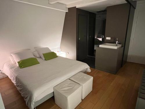 a bedroom with a large white bed with green pillows at Studio de l'Hôtel de Ville in Strasbourg