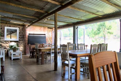 a dining room with tables and chairs and a tv at Gowan Valley Guest Farm in Balgowan