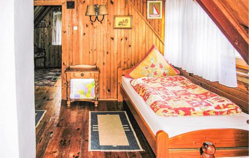 a bedroom with a bed in a wooden room at Stunning Home In Lidzbark Warminski With 2 Bedrooms in Blanki