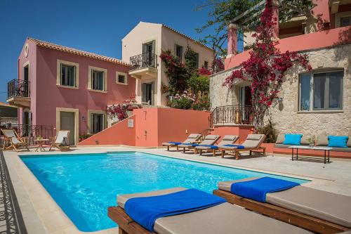une piscine avec des chaises longues et un bâtiment dans l'établissement Roi Boutique Suites, à Asos