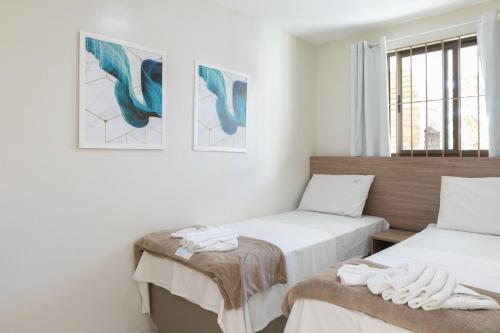 1 dormitorio con 2 camas y ventana en Praia Residence, en Porto de Galinhas