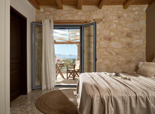 a bedroom with a bed and a stone wall at Villa Zakynthos in Skinária