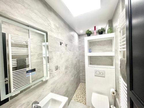 une salle de bain avec un lavabo et des toilettes et une fenêtre dans l'établissement Trouville Plage Casino, à Trouville-sur-Mer