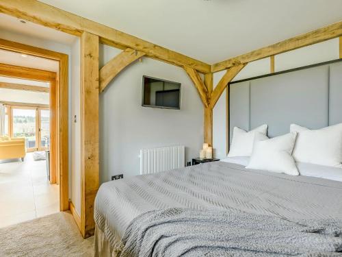 a bedroom with a large bed and a tv at Elm Retreat in Upper Hardres