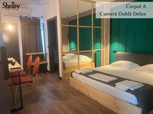a bedroom with a bed and a table and a desk at Hotel Sinner's Shelby in Corabia