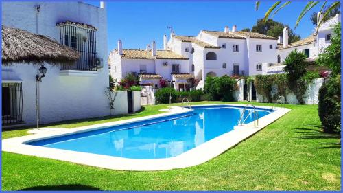 a swimming pool in a yard next to a house at EL PARAISO GOLF Y PLAYA in Estepona