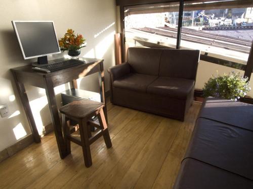 una habitación con un escritorio con una computadora y una silla en Hostal Samichay, en Cusco