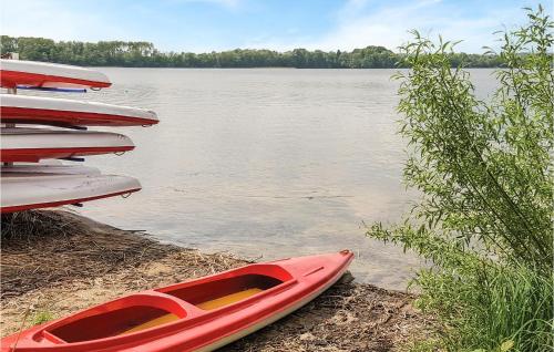 a red kayak sitting on the shore of a lake at Holiday Home Morag Kretowiny Iii in Pojezierce