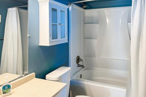 y baño con aseo blanco y ducha. en New River Retreat, en North Topsail Beach