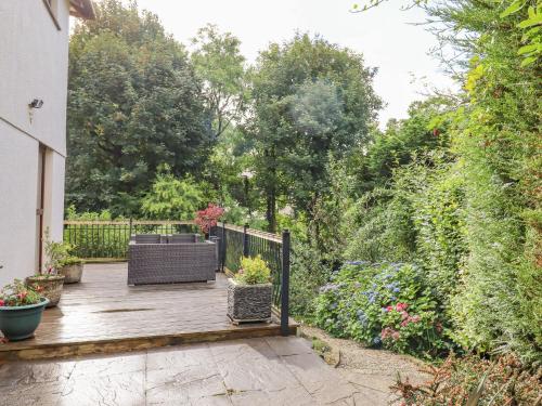 a wooden deck with a bench and some plants at Taw River View in Okehampton
