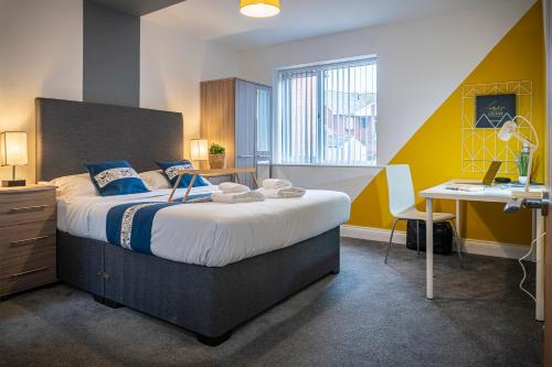 a bedroom with a large bed with a desk and a desk at Spacious 1-Bedroom Home with free private parking in Swansea