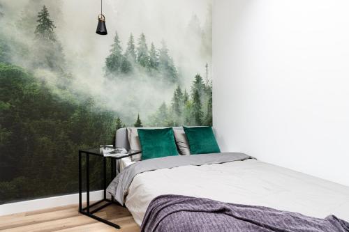 a bedroom with a wall mural of a forest at KOBIELA Luxury Aparthotel KTW City Center in Katowice